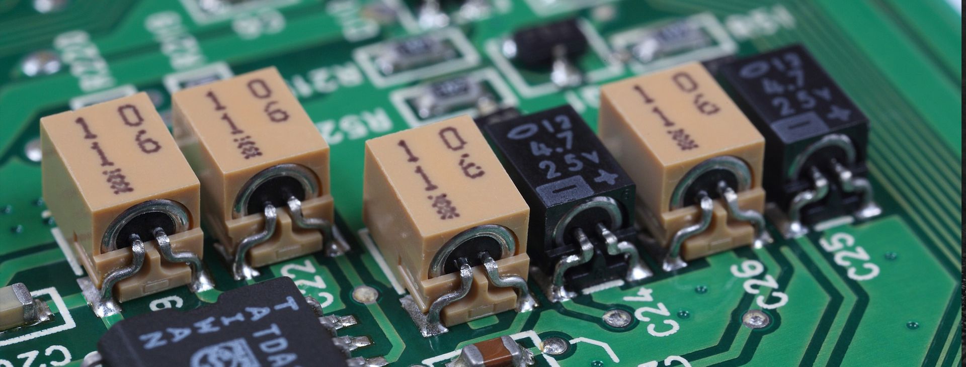 Nahaufnahme mehrerer SMD-Bauteile auf einer bestückten Leiterplatte in der Elektronikfertigung